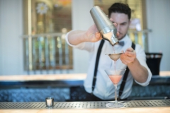 Barman preparing a pineapple and strawberry cocktail