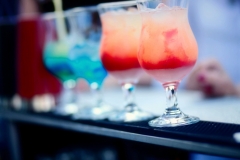 Bartender preparing a cocktail with blue and red syrup